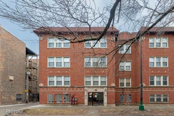 Front view of a three-story brick residential building.