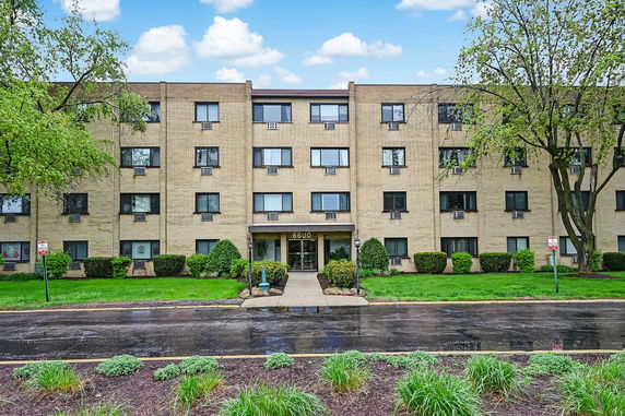 Front view of a multi-story building with a central entrance.