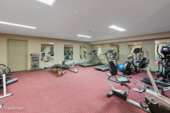 Indoor fitness area with exercise equipment, including treadmills and stationary bikes.