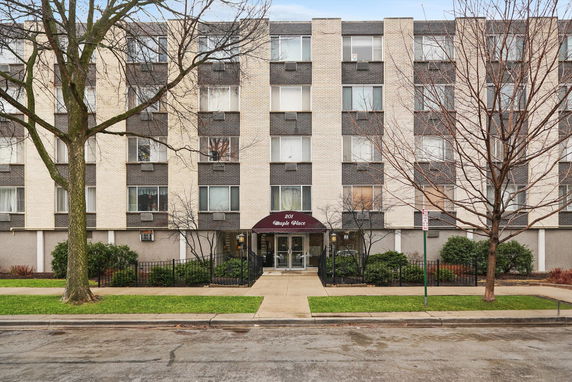 Front view of a multi-story apartment building with a central entrance.
