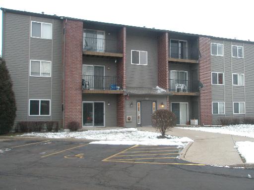 Front view of a multi-story apartment building with balconies.