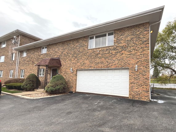 Front view of a two-story brick building with a garage.