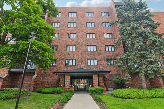 Front view of a multi-story brick building with numerous windows and a central entrance.