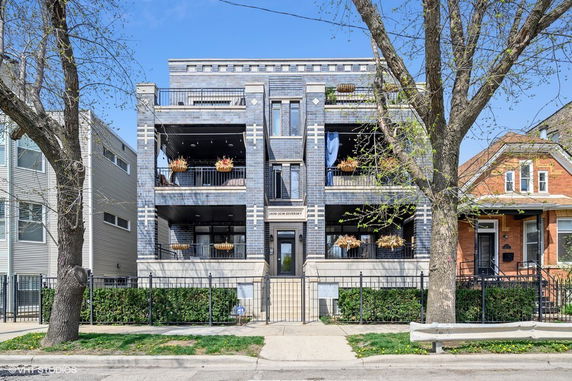 Front view of a multi-story residential building with balconies.