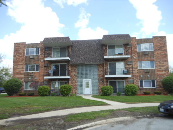 Front view of a three-story brick apartment building.