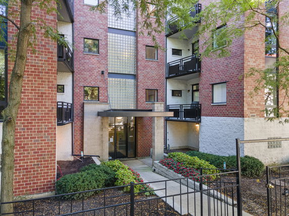 Front view of a multi-story brick building with balconies.