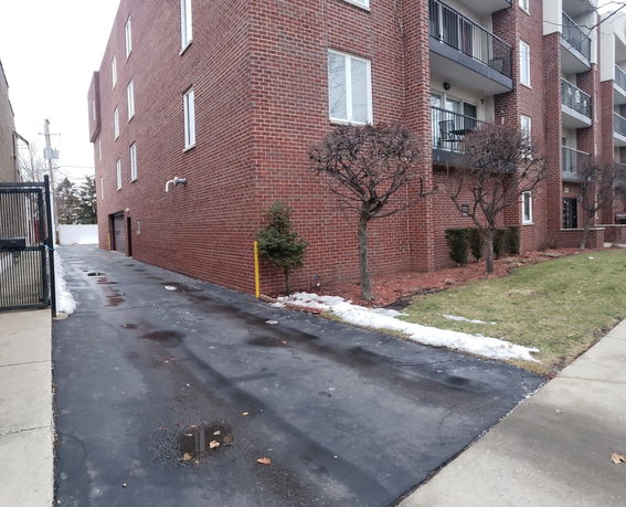 Front view of a multi-story brick residential building with balconies.