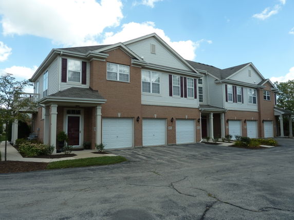 Front view of a two-story townhouse building with multiple garages.