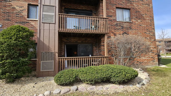 Front view of a brick apartment building with balconies.