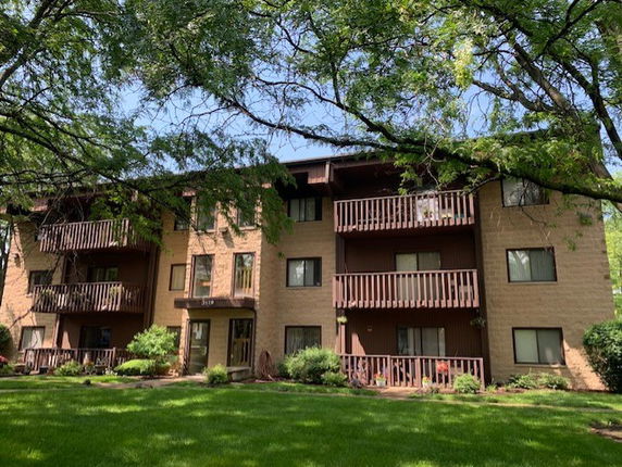 Front view of a multi-story apartment building with balconies.