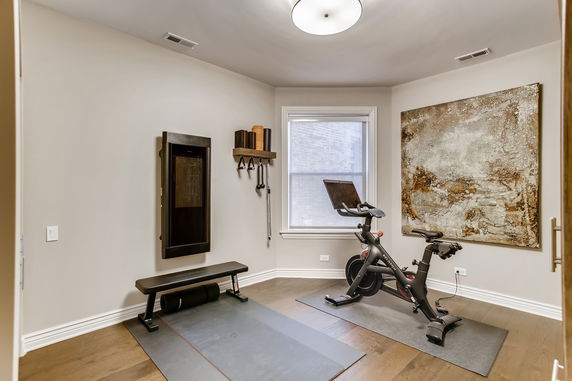 Indoor exercise room with stationary bike and workout equipment.