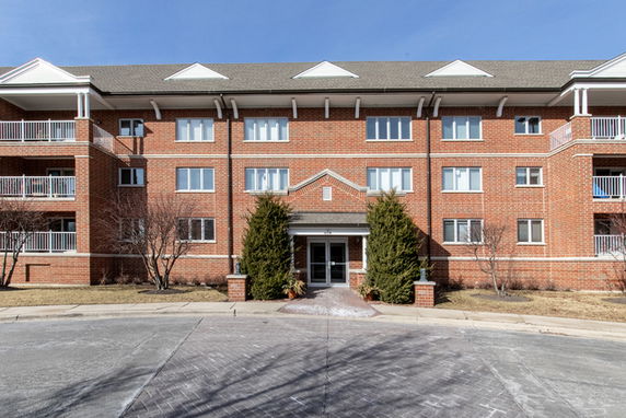 Front view of a three-story brick building with balconies.