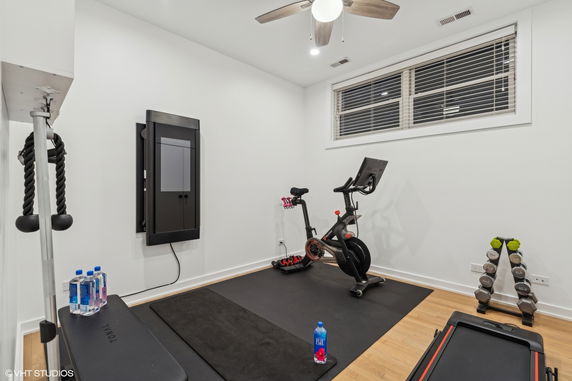 Indoor gym area with exercise bike, weights, and wall-mounted fitness equipment.