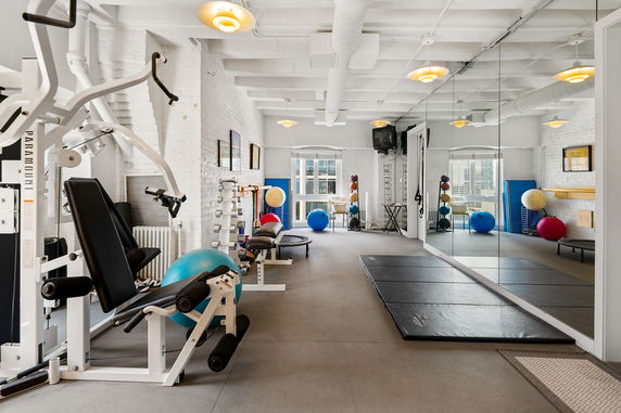 Indoor gym area with exercise equipment and mirrored walls.