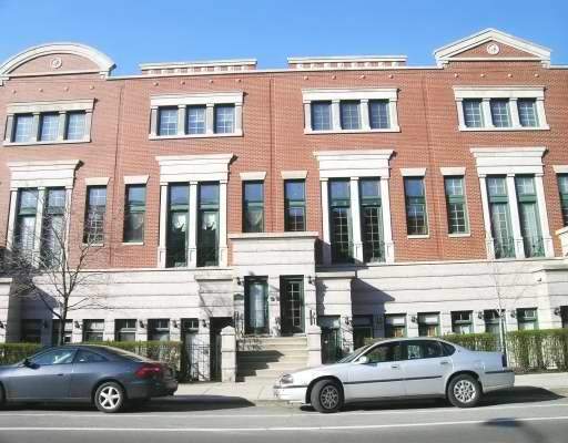 Front view of a multi-story red brick building with large windows and a symmetric design.