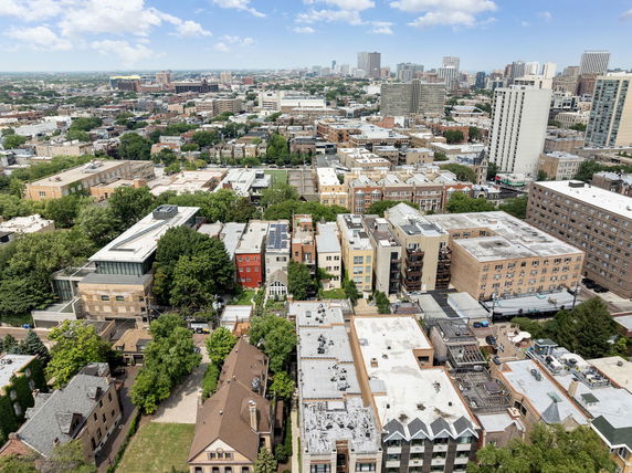 Panoramic view of a cityscape with multiple residential and commercial buildings from a high vantage point.