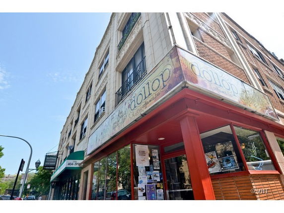 Front view of a multi-story building with a storefront.