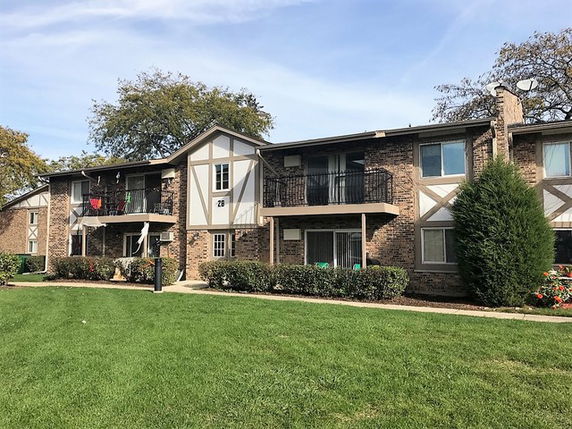 Front view of a two-story apartment building with balconies.