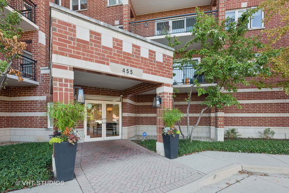 Front view of a brick building with balconies and entrance.
