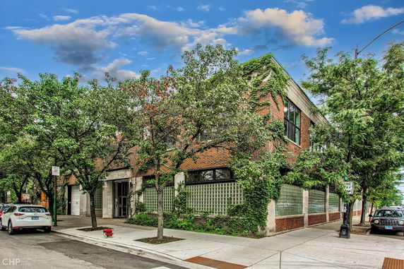 Front view of a two-story brick building with greenery climbing the walls.