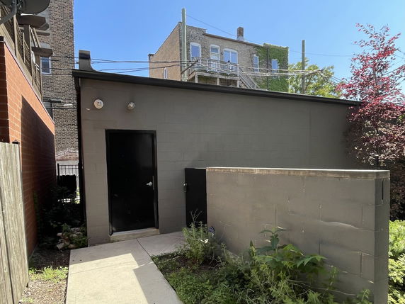 Front view of a small single-story building with a black door.