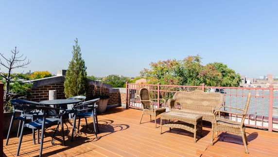 Rooftop patio with outdoor furniture and surrounding views.