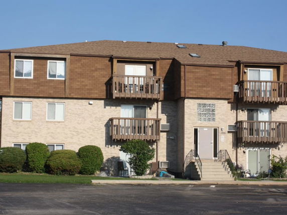 Front view of a two-story apartment building with balconies.