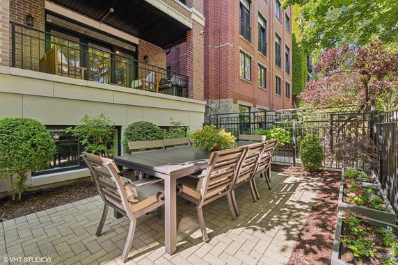 Outdoor patio area with dining table and chairs beside a brick building.