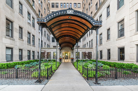 Front view of a multi-story building with an ornate canopy entrance.