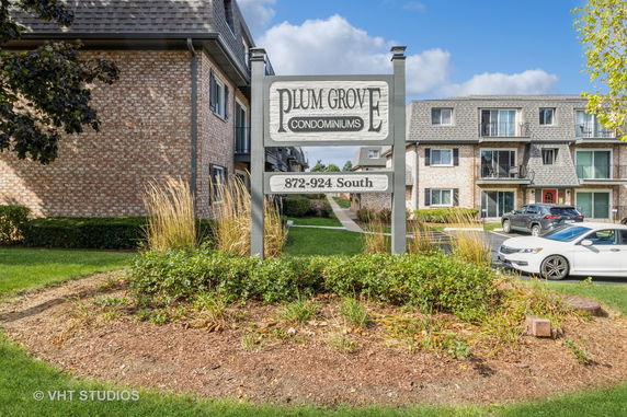 Front view of a condominium complex with a prominent sign and multiple balconies.