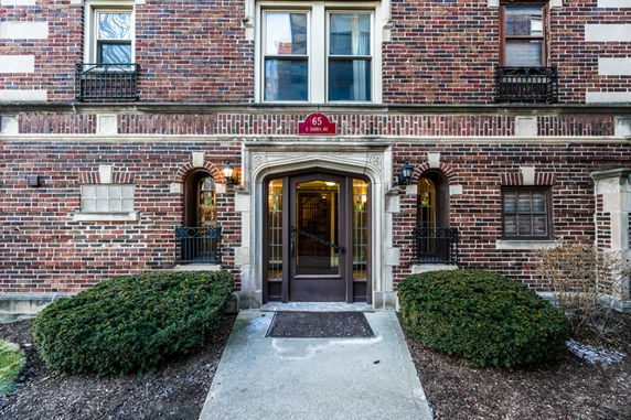 Front view of a brick apartment building with an arched entrance.