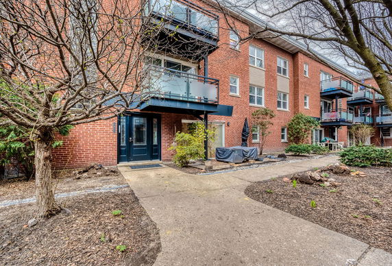 Front view of a multi-story brick building with balconies and a main entrance.