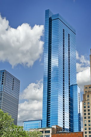 Front view of a tall glass-covered skyscraper.