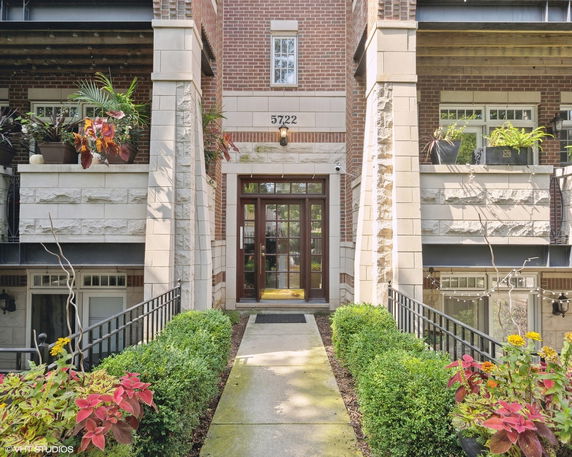 Front view of a multi-story brick building with balconies and a main entrance.