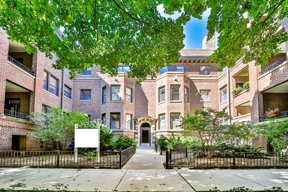 Front view of a brick apartment building with multiple stories.