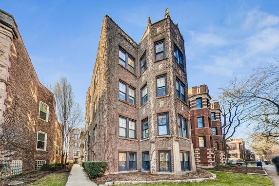 Front view of a multi-story apartment building with brick exterior.