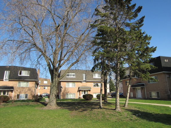 Front view of a multi-story brick building with dormer windows.