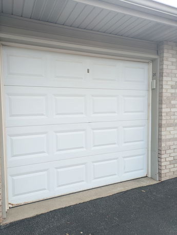 Front view of a garage door in a brick building.