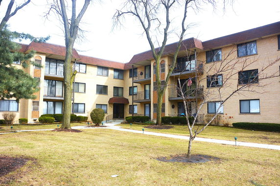 Front view of a multi-story apartment building with brick exterior.