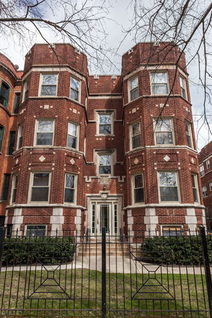 Front view of a multi-story brick building with distinctive architectural details.