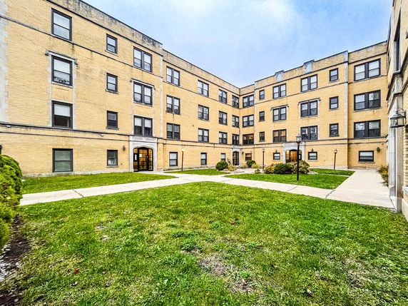 Front view of a multi-story apartment building with brick exterior.