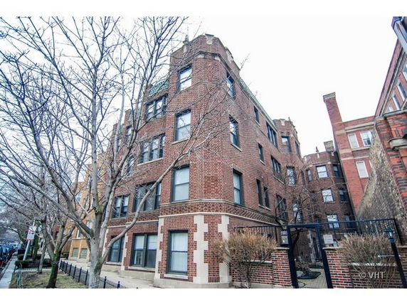 Front view of a multi-story brick building with multiple windows.