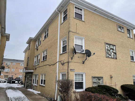 Corner view of a three-story brick apartment building