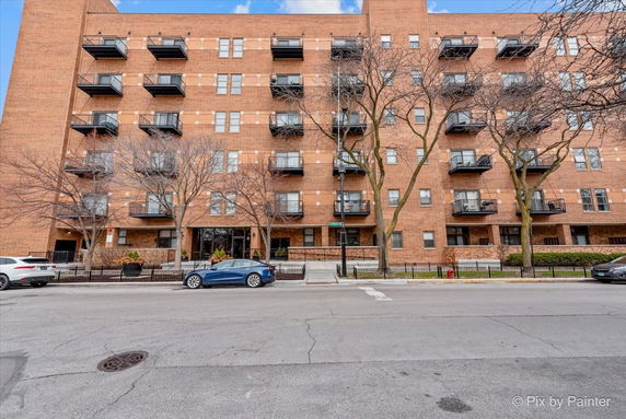 Front view of a multi-story brick building with balconies.