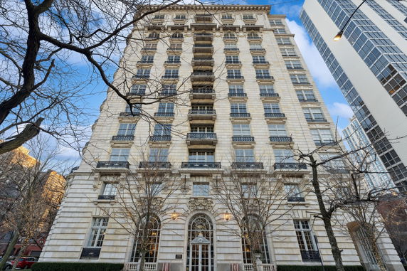 Front view of a multi-story residential building with numerous windows and decorative balconies.