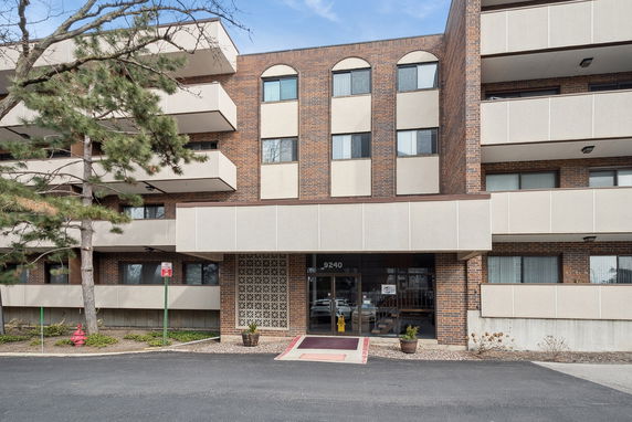 Front view of a multi-story building with balconies and a central entrance.