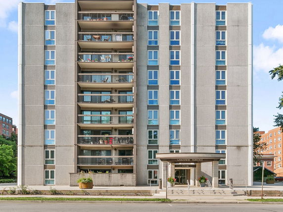 Front view of a multi-story apartment building with balconies.