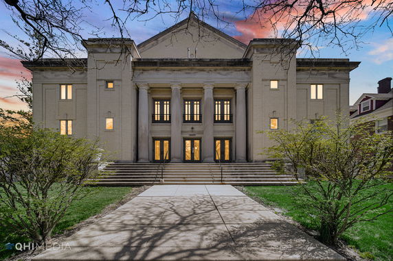 Front view of a large building with classical architectural elements and multiple columns.