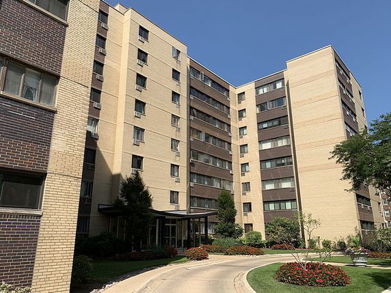 Front view of a multi-story apartment building with a central entrance.