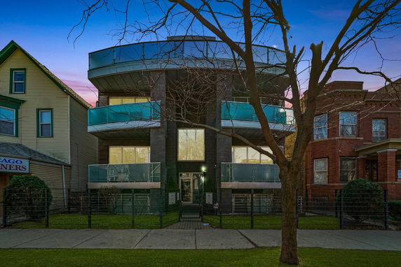 Front view of a multi-story building with glass balconies.